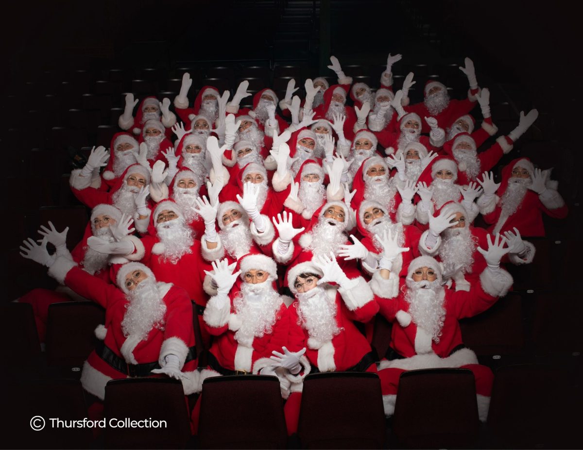 A large group of people dressed up as Father Christmas in red suits and white beards