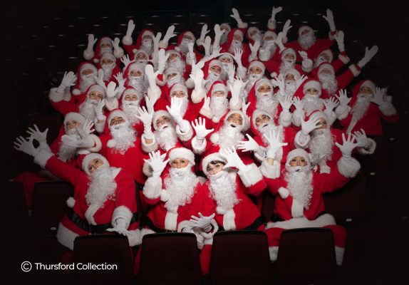 A large group of people dressed up as Father Christmas in red suits and white beards